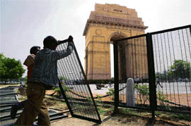 A worker sets up barricades near India Gate on the route of the Olympic Torch in New Delhi on Tuesday. 