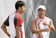 Indian Davis cup tennis player Leander Paes (R) gestures as he talks with teammate Rohan Bopanna (L) during a practice session in New Delhi