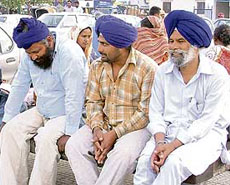 Farmers await a train from from Bihar to hire farm hands for harvesting wheat at the Ludhiana railway station on Tuesday.