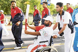 Para-Olympics competitor Rajender Singh carries the Olympic torch during the torch relay in New Delhi