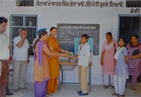 Members of the Shah Satnam Ji Green-S Helpline Committee, Bathinda, observing the anniversary of the Jam-e-Insaan Guru Ka ceremony at the government elementary school, Chandsar Basti, in Bathinda