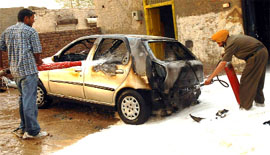 Firemen busy dousing flames that gutted a car at Azad Nagar in Bathinda on Thursday.