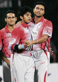 Kings XI Punjab pacer Sreesanth celebrates the wicket of Bangalore Royal Challengers' Cameron White with teammate VRV Singh during the IPL T20 match at Chinnaswamy stadium in Bangalore