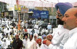 Former ministers Pratap Singh Bajwa and Raman Bhalla discuss a point at a dharna by Congress leaders at Sathiali village, near Gurdaspur, on Sunday. 
