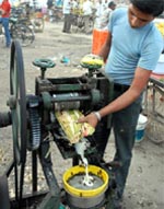 Unhealthy drink: A swarm of bees and flies sipping cane juice that a vendor was preparing for customers on Goniana Road