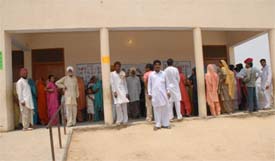 Voters in Midu-Khera village in Muktsar district wait for their turn to cast ballot as doors of the polling booth was bolted from inside. 