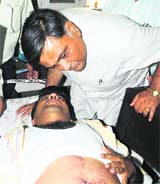 Minister Manoranjan Kalia talks to an injured of a clash between SAD and BJP workers in Bathinda on Monday. 
