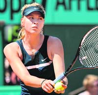 Russia�s Maria Sharapova serves to her compatriot Evgeniya Rodina during their French Open first round match at Roland Garros, on Wednesday in Paris. Sharapova won 6-1, 3-6, 8-6.