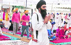 A Sikh youth with a gun performs ardas at Akal Takht to mark Ghallughara Divas in Amritsar