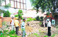 MC employees demolish the boundary wall of Ram Bagh to construct gate for a cafeteria in Maharaja Ranjit Singh Panorama