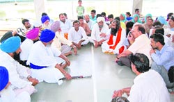 Residents of Maadh village (left) try to persuade members of the families, who fled the village following alleged threat by an Akali leader, to return to the village