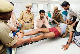 An injured CRPF head constable is carried on to a bed by colleagues and medical staff at the main hospital in Srinagar on Saturday.