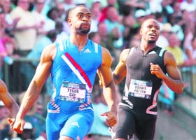 Tyson Gay (L) reacts after crossing the finish line to win the men's 100 meters final at the U.S. Olympic Track and Field Trials in Eugene, Oregon
