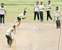 Pakistan bowler Rao Iftikhar (top-C) delivers a ball as teammates look on during a team training session in Karachi on Tuesday.