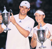 Bob Bryan (left) of the USA and Australia's Samantha Stosur hold their trophies aloft after wining the mixed doubles final at Wimbledon on Sunday.