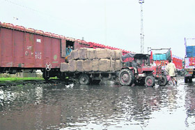 Bales of gunny bags being unloaded outside the railway head terminal in Amritsar. In the absence of sheds, goods have to be unloaded directly to tractor-trailers.