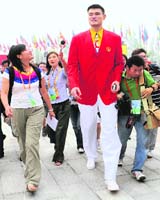 NBA basketball player Yao Ming (C) walks surrounded by media representatives before the start of the official opening ceremony of the Olympic village in Beijing