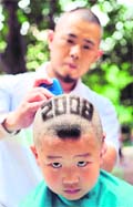 A young Chinese boy has hair cut with Beijing Olympic Games emblem hairstyle to show their support for the upcoming Beijing Olympics at a school in Beijing on Tuesday.