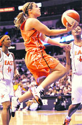 San Antonio Silver Stars' Becky Hammon (C), playing for the Western Conference, goes up for a basket in front of Detroit Shock's Kara Braxton (R) and Deanna Nolan (L), both playing for the Eastern Conference, in the second quarter of the WNBA All-Star game in Washington in this July 15, 2007 file photo.