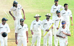 Members of India's cricket team celebrate as they walk back to the pavilion after their victory over Sri Lanka in their second Test match in Galle