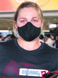 A cyclist from the U.S. team arrives wearing a mask at Beijing airport to participate in the 2008 Beijing Olympic Games