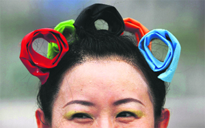 A woman wears hair bands in the shape of the Olympic rings before the opening ceremony of the Olympic Games at the National Stadium on Friday.