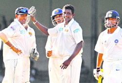 Ajantha Mendis (2R) celebrates with teammates the dismissal of Sachin Tendulkar (R) during the third day of the third Test between India and Sri Lanka at The P. Saravanamuttu Stadium in Colombo on Sunday. 
