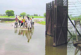A view of flooded barbed wire fencing gate at the entrance of Bhaini Dilawar village in Fazilka.