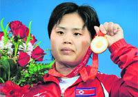 Pak Hyon Suk of North Korea poses during the awarding ceremony for the women's 63kg weightlifting event at the 2008 Beijing Olympic Games