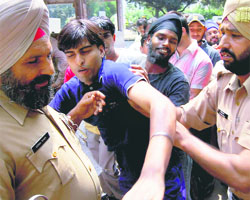 Policemen drag a visually challenged protester in front of the main gate of the Punjab mini-secretariat in Chandigarh on Monday.