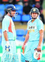 Mahendra Singh Dhoni (L) and Suresh Raina speak during the fourth ODI match at the R. Premadasa Stadium in Colombo
