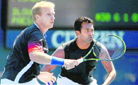 Lukas Dlouhy (L) of the Czech Republic and Leander Paes of India play at the net against Ashley Fisher of Australia and Rik De Voest of South Africa during the US Open. 
