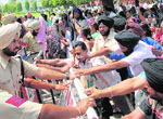 Punjab-aided school teachers try to break a police barricade at the venue of the function.