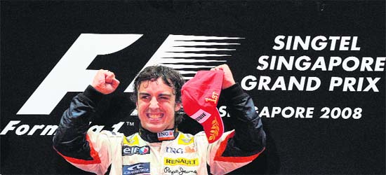 Spain's Fernando Alonso of Renault gestures as he celebrates his victory on the podium after the end of Formula One's Singapore Grand Prix