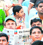 A cricket fan reads The Tribune at the PCA Stadium on Saturday.