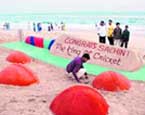 Sand artist Sudarsan Patnaik makes a 12ft long sand cricket bat to mark Sachin Tendulkar's 12,000 Test runs in Puri beach on Saturday. 