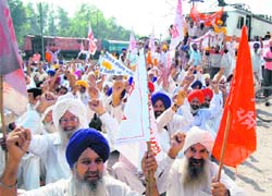 Farmers block a train as part of a statewide rail roko in Amritsar