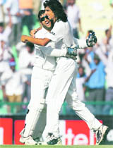 Mahendra Singh Dhoni and Ishant Sharma (R) celebrate the dismissal of Australia�s Shane Watson on the fourth day of the second Test in Mohali on Monday. 