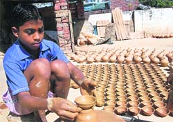 A child prepares earthen lamps for Diwali in Dehradun on Wednesday.