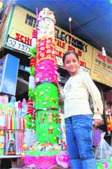 A girl stands beside a giant-sized candle. 