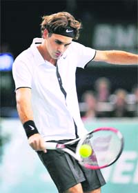 Roger Federer of Switzerland returns the ball to Robin Soderling of Sweden during their match at the Paris Masters Series tennis tournament