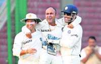 Mahendra Singh Dhoni  and Sachin Tendulkar  lift teammate Virender Sehwag as they celebrate the wicket of Michael Hussey during the third day of the third Test match between Indian and Australia at the Ferozeshah Kotla stadium in New Delhi