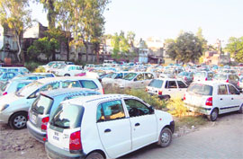 Cars parked in parking lot near Clock Tower, Dehradun. 