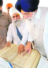 SGPC president Avtar Singh has a look at a rare hand-written manuscript preserved at the historic Aurangabad gurdwara.