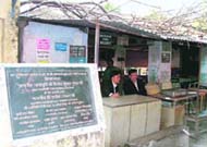 Branches of the tree lying on the tin shed. Also seen is the foundation stone laid this April by Uttarakhand Chief Justice, V.K.Gupta, for the proposed multi-storey building. (Above) A view from the outside.