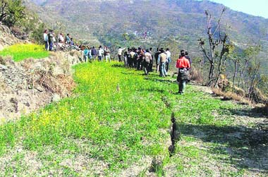 Cracks appear in a field along the banks of Tehri Lake. 