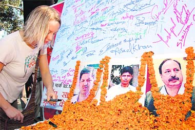 A foreign tourist signs a condolenc message in memory of martyred policemen in Dehradun on Tuesday. 