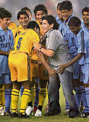 Former football star Diego Maradona (C) is greeted by Indian footballers in Kolkata.
