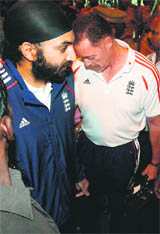 Monty Panesar (L) walks towards the team bus upon arrival at the city airport in Chennai.