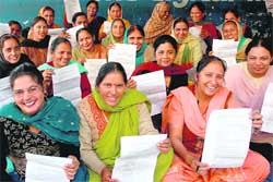 Jubilant anganwadi workers show their appointment letters outside the office of the director, Social Security, Women and Child Development, Punjab, at Sector 34 in Chandigarh